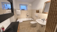 Badezimmer mit Wanne/Dusche und WC
