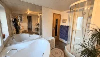 Badezimmer mit Eckwanne/Dusche und WC